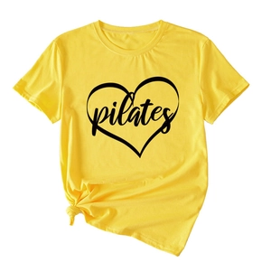 Detail of lemon yellow cotton Pilates t-shirt featuring heart print and stylish knotted hem