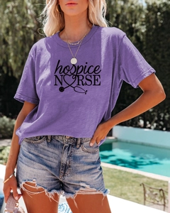 Détail de l'imprimé hospice nurse et logo stéthoscope en cœur sur t-shirt violet