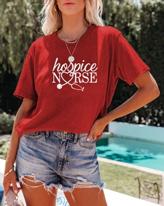 Détail du t-shirt rouge hospice nurse porté avec un short en jean en extérieur