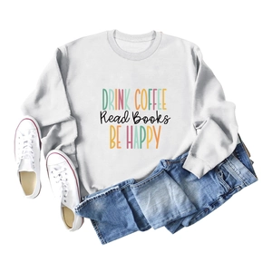 Flat lay of white sweatshirt with 'DRINK COFFEE' print paired with jeans and shoes