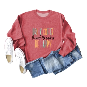Detailed flat lay of a rust red long sleeve sweatshirt with Drink Coffee graphic print