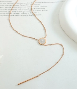 Dettaglio della collana a Y in oro rosa con ciondolo a sole e strass micro-incastonati