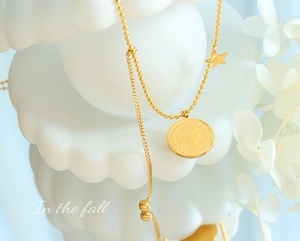 Vue macro du collier avec pendentif pièce d'or, étoile et maillons de perles