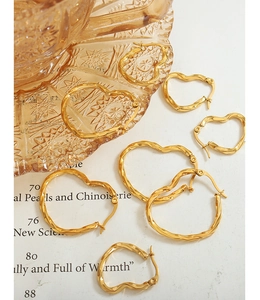 Détail de boucles d'oreilles cœur torsadées dorées en petites, moyennes et grandes tailles