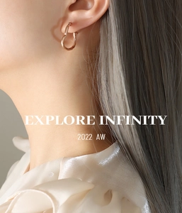 Gros plan de boucles d'oreilles cœur torsadé en or rose portées par un mannequin