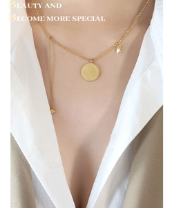 Gros plan du collier avec pendentif pièce d'or et étoile sur mannequin avec chaîne à perles