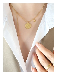 Détail du pendentif pièce d'or avec portrait et étoile sur collier à billes fines