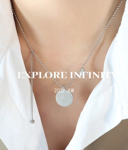 Détail du collier à billes argenté avec pendentif pièce de monnaie et pampille étoile