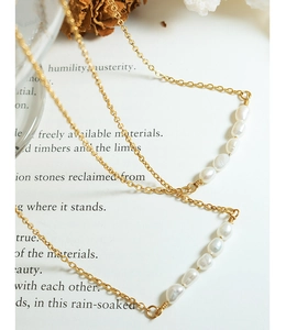 Détail de cinq perles baroques sur un collier en acier inoxydable plaqué or 18 carats