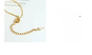 Détail d'un collier en acier doré avec perle d'eau douce blanche et fermoir anneau à ressort