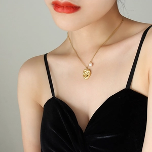 Collana placcata oro con ciondolo irregolare e perla d'acqua dolce su una modella
