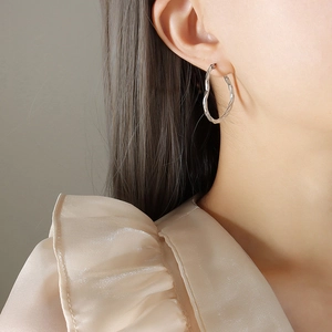 Élégantes créoles torsadées en argent au design de corde portées par un mannequin femme