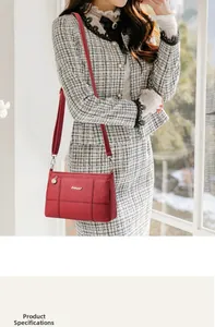 Close-up of red crossbody square bag featuring gold logo and textured leather finish