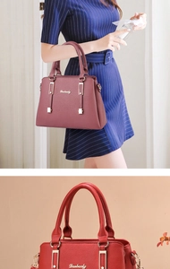 Dettaglio borsa shopper in finta pelle rossa con finiture dorate e logo