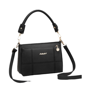 Minimalist black quilted tote bag with pebbled leather texture and adjustable strap