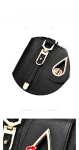 Detail of elegant black leather bag featuring glossy gold hardware hooks and geometric lock