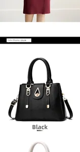 Close-up of black leather handbag featuring golden metal hardware and stitch details