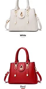 Close-up of white and red leather tote bags with gold teardrop locks and handles