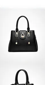 Front view of black textured leather handbag with elegant gold teardrop hardware
