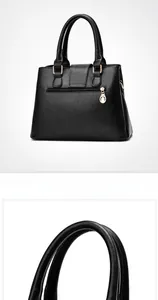 Detail of black pebbled leather tote bag featuring a rear zipper pocket and gold charm