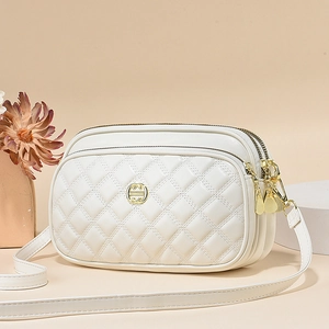 White quilted faux leather crossbody bag with three zipper compartments and gold hardware