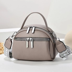 Chic taupe pebbled leather handbag with double zippers and wide geometric strap