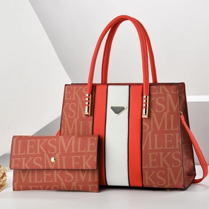 Detail of red-brown and white faux leather tote with letter prints and triangular emblem