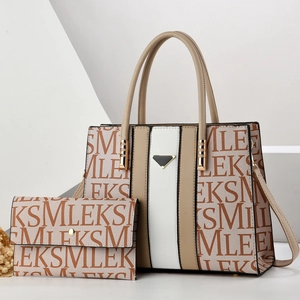 Detail view of the beige patchwork tote bag set with monogram print and metal triangle trim