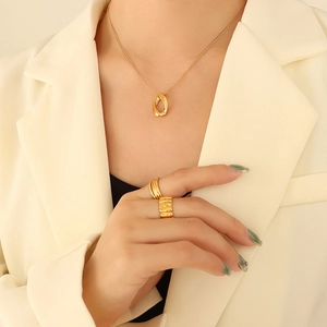 Parure de bijoux dorés minimalistes avec pendentif géométrique torsadé et bagues larges