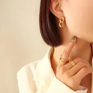 Parure de bijoux dorés géométriques avec boucles d'oreilles et bagues sur mannequin
