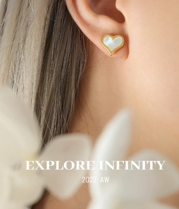 Gros plan de boucles d'oreilles cœur en or avec incrustation de nacre blanche