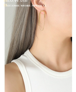 Détail de boucles d'oreilles chaîne en U plaquées or 18k portées par un mannequin
