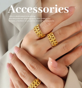 Detail shot of stacked golden Cuban link rings on a model showing a trendy fashion look