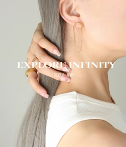 Boucles d'oreilles U en or 18k avec chaîne et bagues côtelées portées par un mannequin