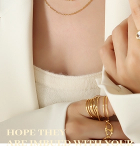 Détail macro d'un ensemble de bagues et collier en or au design minimaliste superposé