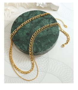 Détail du collier double couche doré avec maille Figaro et fermoir mousqueton robuste