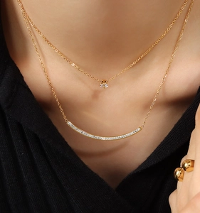 Close-up of double layer gold necklace with zircon diamond pendant and smile bar design