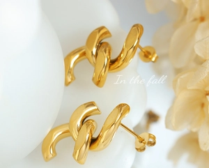 Détail de boucles d'oreilles nœuds dorés avec finition polie et fermoirs papillons