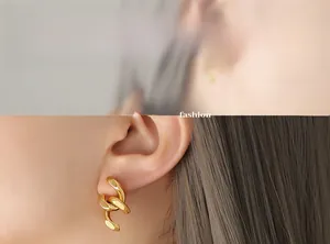 Gros plan de boucles d'oreilles en chaîne dorée à maillons épais avec fini poli