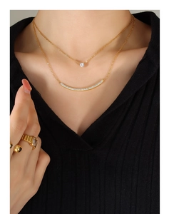 Close-up of double layer gold necklace with zircon stone and curved pavé bar on neck