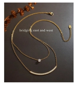 Detailed macro view of gold-plated double layer necklace with zircon pendant on dark background