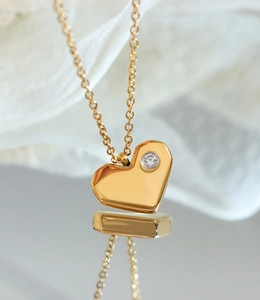 Gros plan du pendentif cœur plaqué or avec zircon et chaîne fine en acier titane