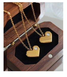 Détail de colliers avec pendentif cœur et zircons dans un écrin à bijoux en bois