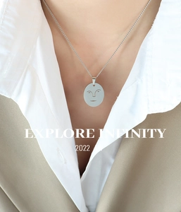 Détail d'un collier minimaliste en acier inoxydable avec pendentif visage sur un mannequin