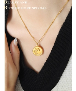 Détail du collier avec pendentif pièce d'or à motif de vagues sur chaîne perlée