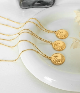 Détail de chaînes perlées plaquées or 18K avec pendentifs en relief vague d'océan