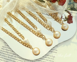 Detail of 18k gold plated chain with freshwater pearl pendant and baroque accent