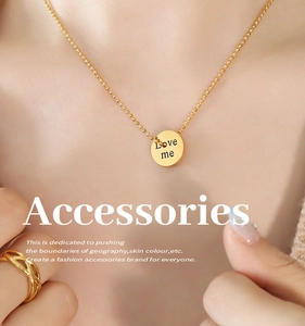 Close-up of gold beaded chain necklace with 'Love me' pendant and cutout ring