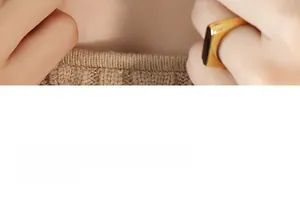 Detail of a vintage gold signet ring with a black rectangular inlay on a model's hand