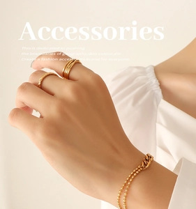 Detail of 18k gold plated stainless steel bead bracelet and textured rings on model